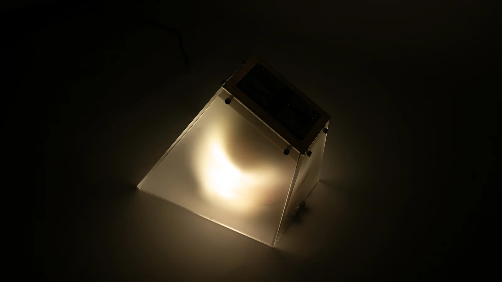 Quarter / Light glowing through its angled acrylic enclosure
