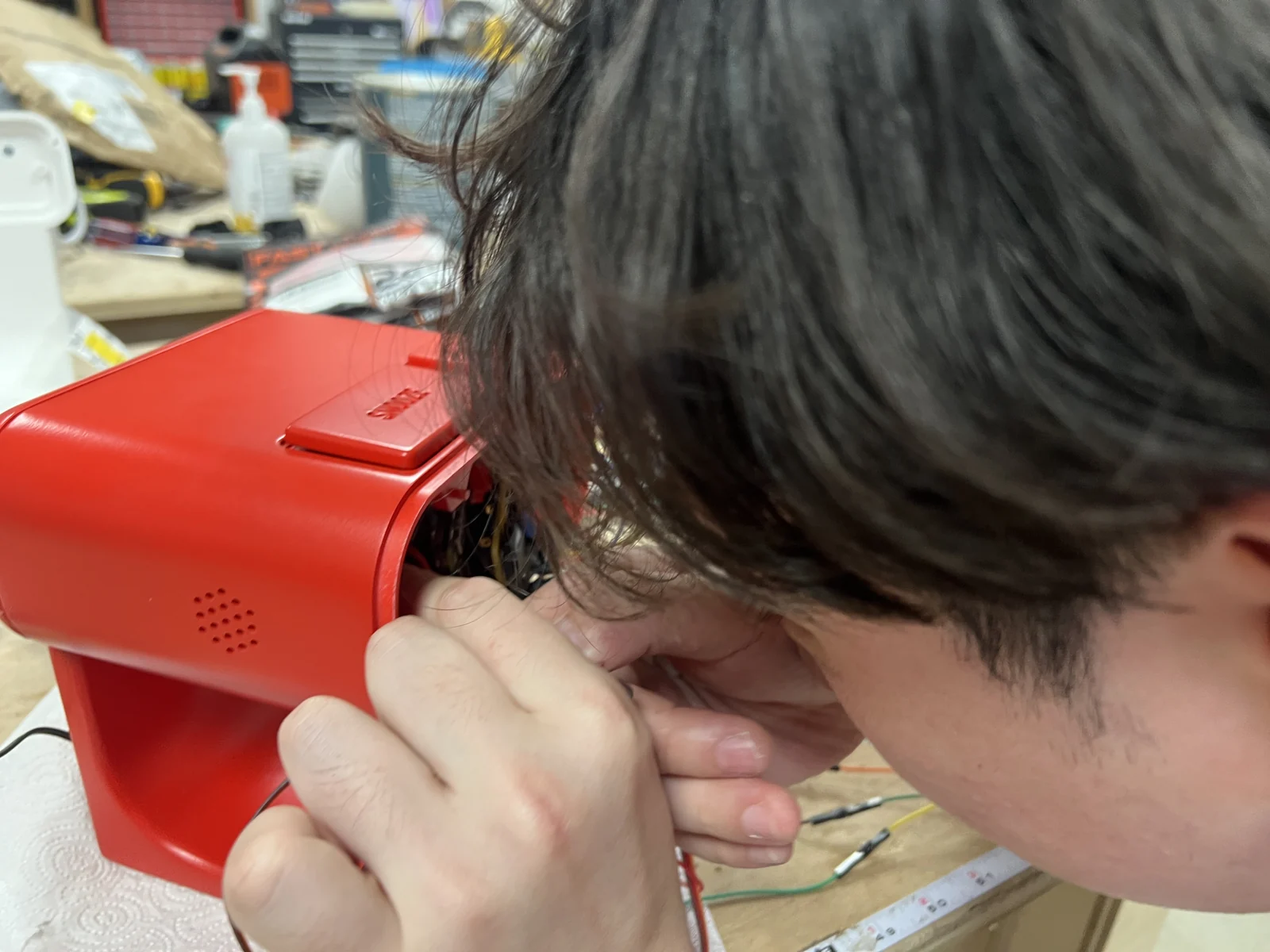 Working on the electronics inside a red clock body