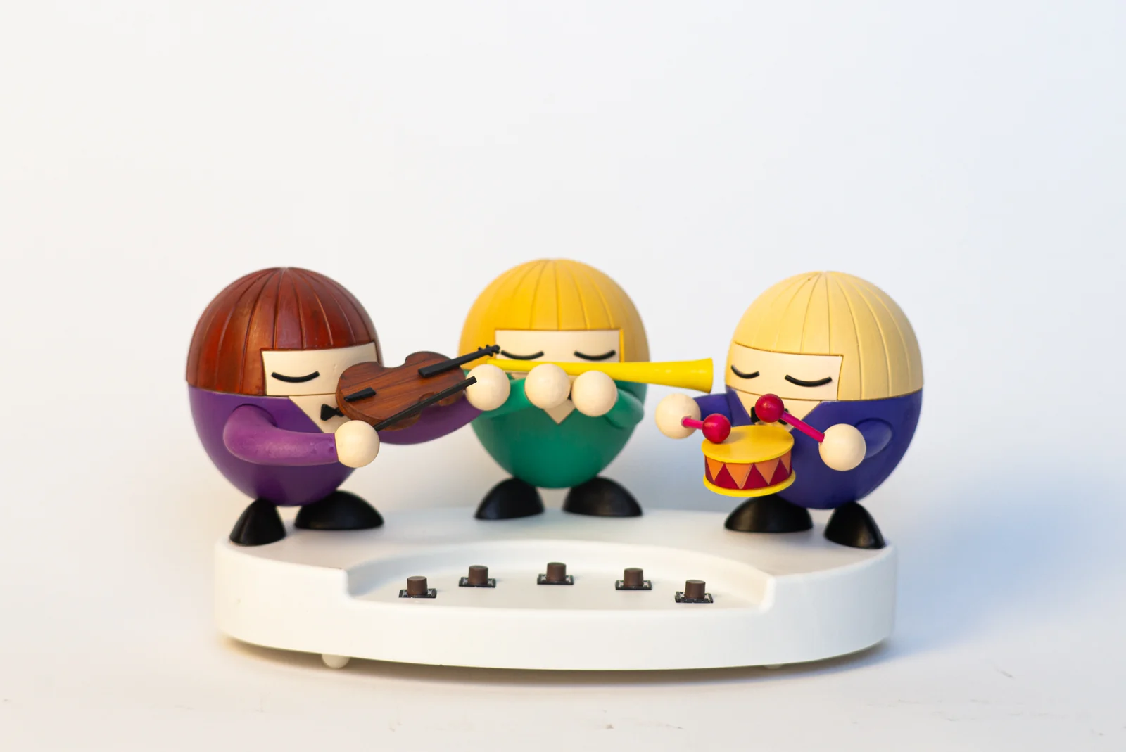 Three musicians arranged above a row of five buttons