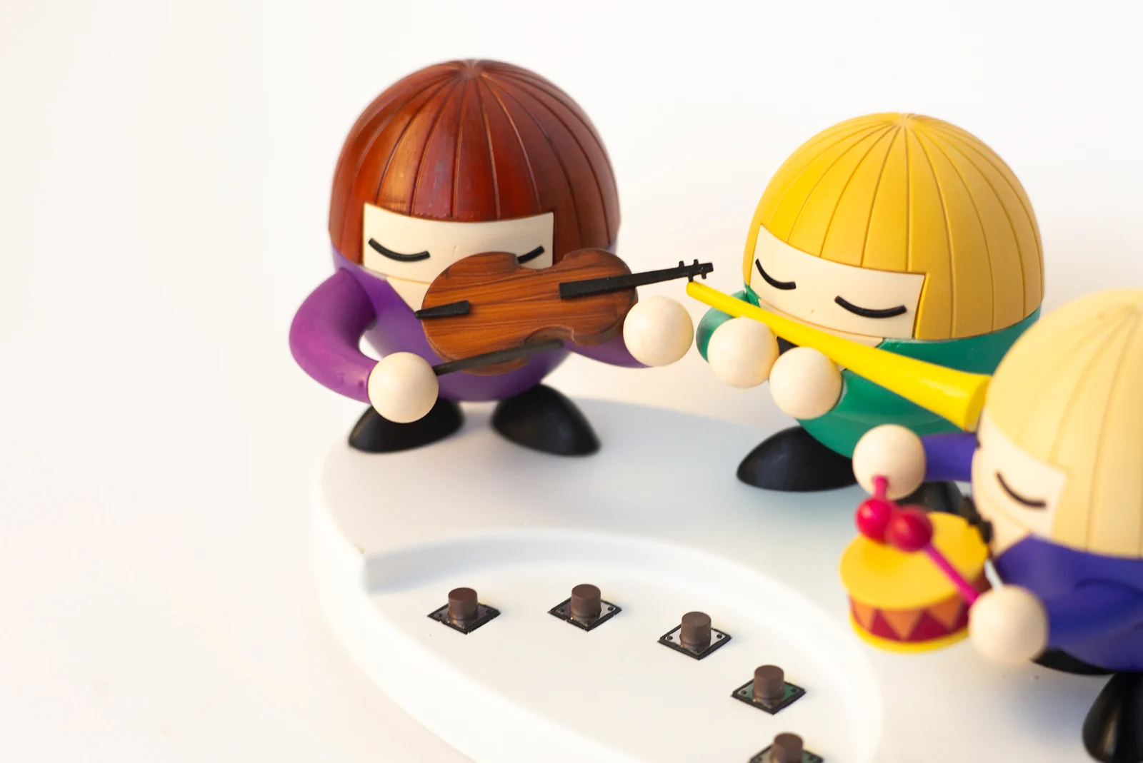 Three miniature musicians above the Moodmaker Orchestra’s five buttons
