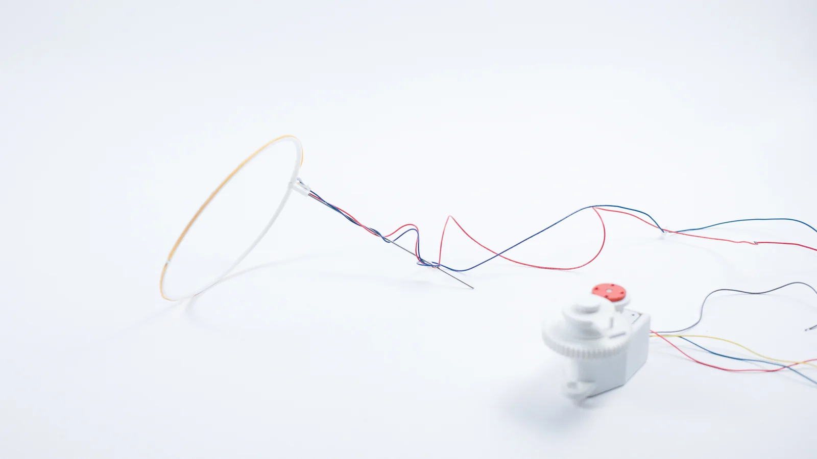 LED halo connected by exposed wires to a small hand crank