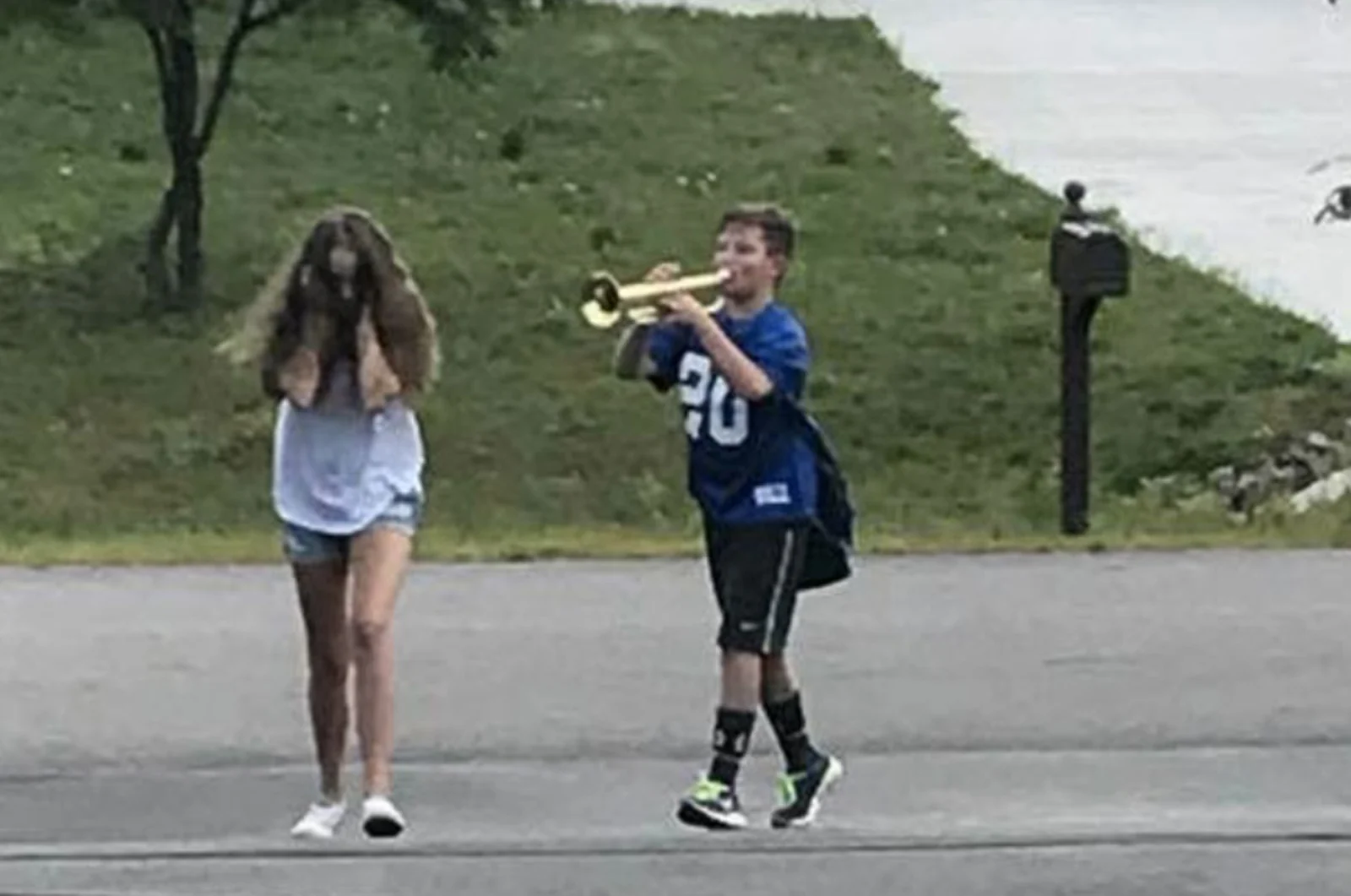 The original meme of a boy playing a trumpet beside a girl covering her ears
