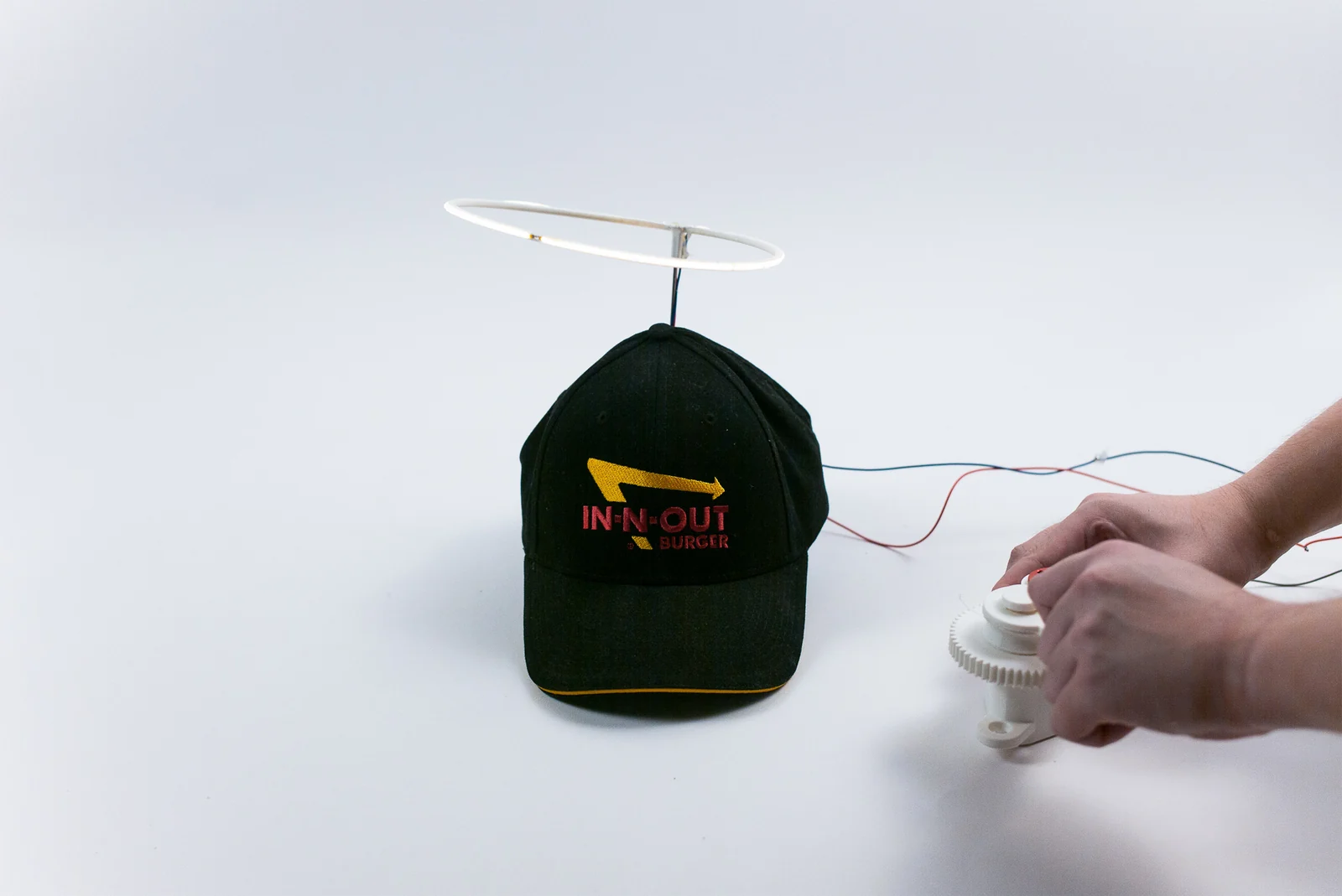 A hand turns the crank to illuminate the halo above the hat