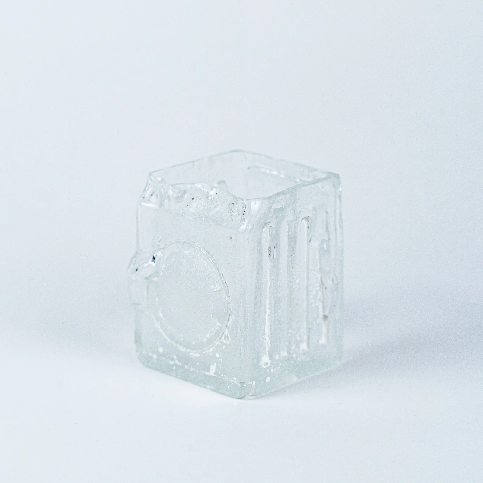 Clear glass object shaped like a washing machine