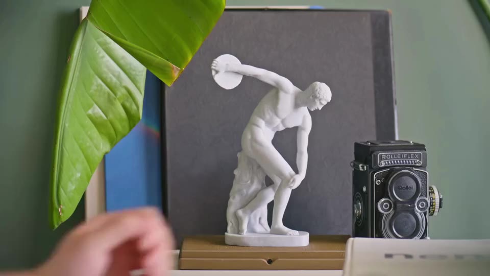 The finished marble-textured statue beside green leaves
