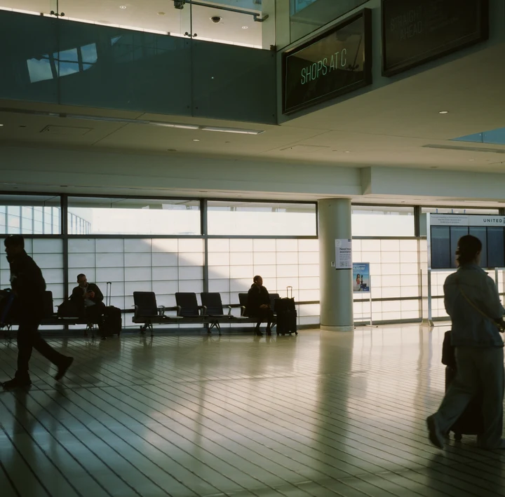 Silhouettes beside tall windows in a spacious hall