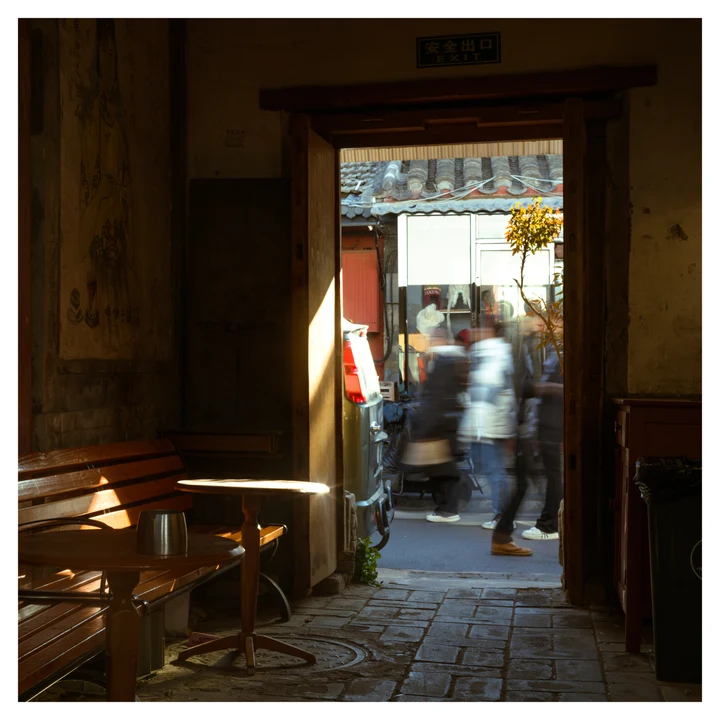 People beyond a doorway in a dim interior