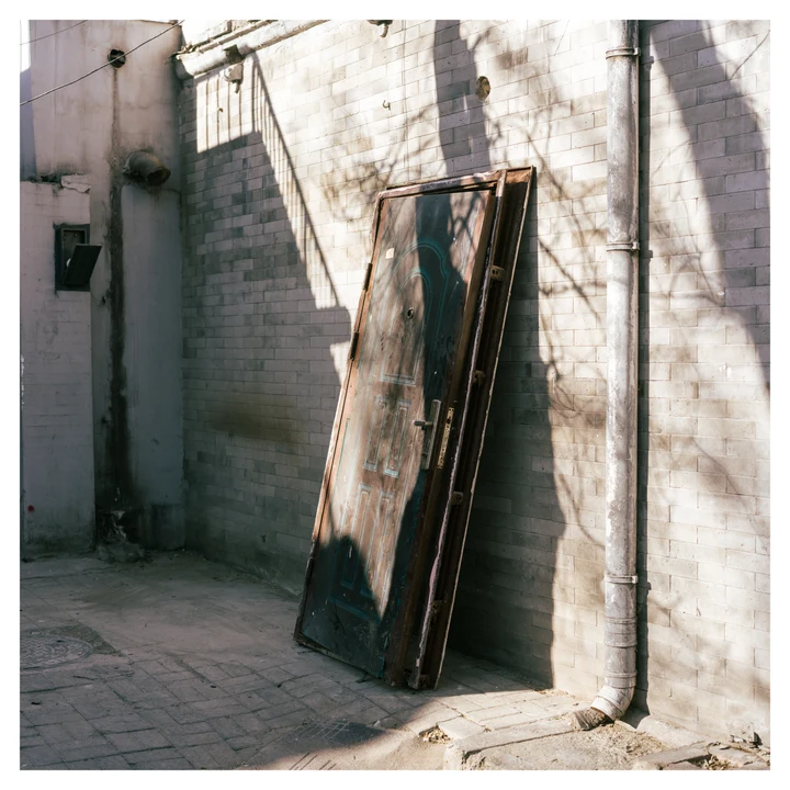 A window frame leaning against a sunlit wall
