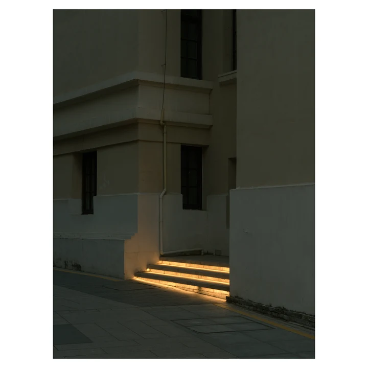 A stripe of sunlight on steps outside a building