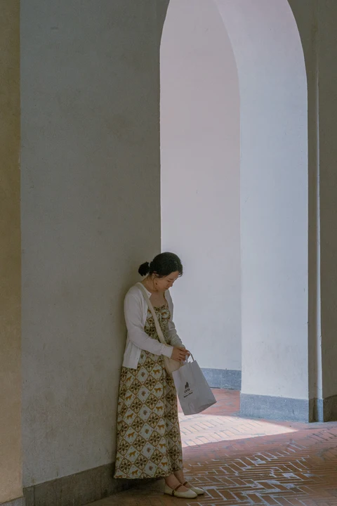 A person in a long dress standing in an archway